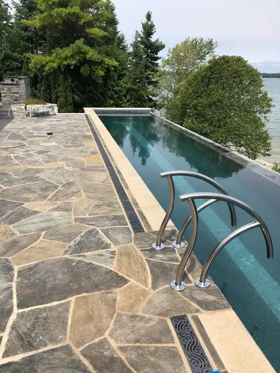 Narrow infinity-edge pool with flagstone coping and the lake beyond