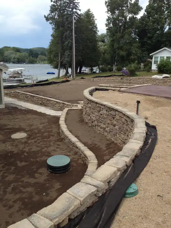 A curved stone retaining wall beside a lakeside pool