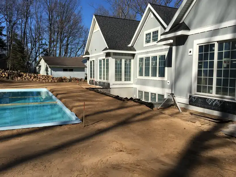 A spa and pool shell set beside a grey house