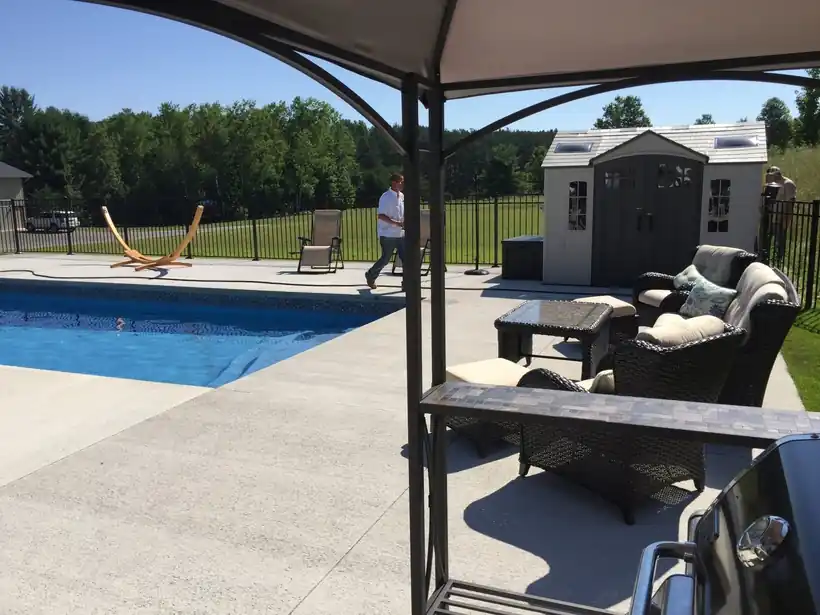Patio, gazebo and concrete deck beside a pool