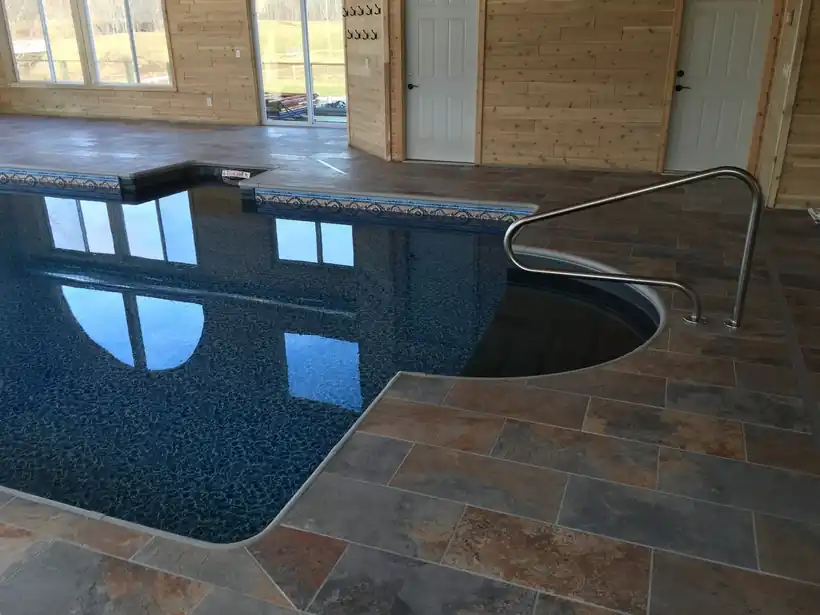Indoor vinyl pool with slate tile and timber walls